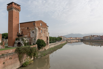 Fototapeta na wymiar The Guelph Tower and Medici Citadel on the Arno River in Pisa, T
