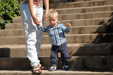 Mom teaches baby to go down the stairs