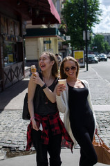 Two girlfriends are eating icecream