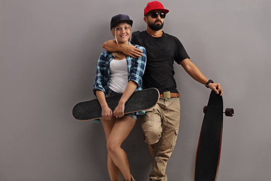 Guy with longboard and hipster girl with skateboard