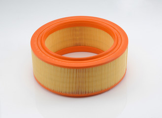 automotive filter cylindrical shape of orange color on a white background