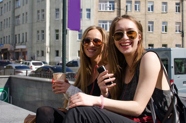 Two girlfriends are playing with the cellphone