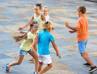 Group of  children running outdoors in city street