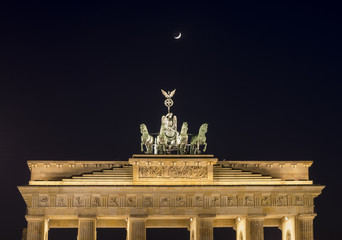 Obraz premium Brandeburg gate at night with Moon (Berlin, Germany)