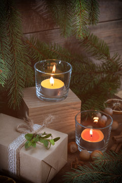 Two light candles with Christmas and New Years decor and Christmas tree on dark wooden background