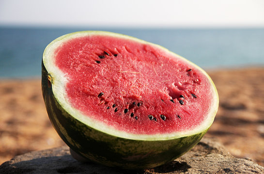 Half Of Ripe Juicy Watermelon On Stone At Beach