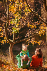 Father hugs a little daughter while sitting with her mother unde