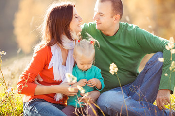 Mom and dad admire each other while sitting on the ground with t