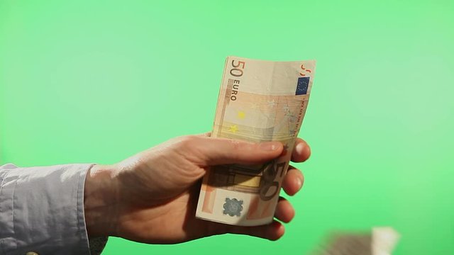 Close up of hands counting various european euro notes over green background.