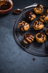 decorating profiteroles with melted hot chocolate