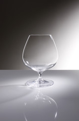 Still life with a empty cognac glass, on a grey background.