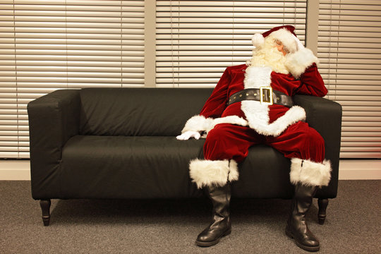 waiting for christmas job, santa claus sleeping on sofa in office