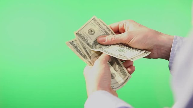 American Dollar Bills being counted. Filmed from close up and behind a green isolated screen.