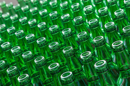 a large number of transparent glass bottles of green color closeup