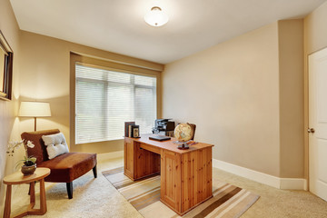 Interior of home office with beige walls and wooden desk