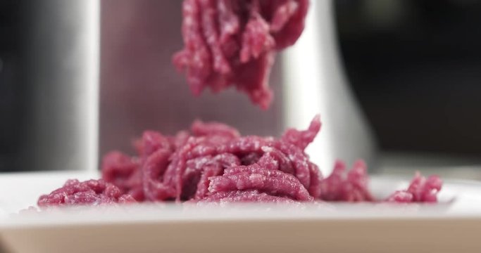 mincing beef meat with electric mincer