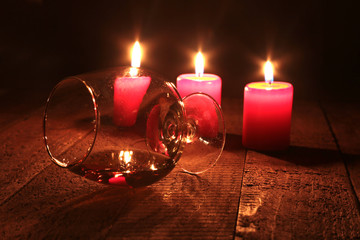 Christmas Composition with glass cognac, Gift box and candle on wooden table
