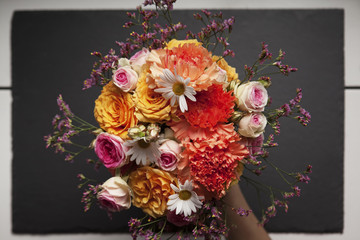 bouquet of flowers hold by a hand. top view