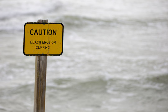 Warning sign on the beach erosion cliffing