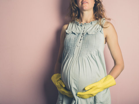 Pregnant woman wearing rubber gloves
