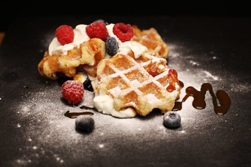 Fresh homemade waffles with ricotta served with whipped cream and berries