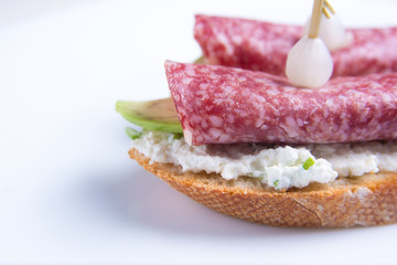 Bruschetta crostini with salami, avocado and ricotta cheese. Italian cuisine