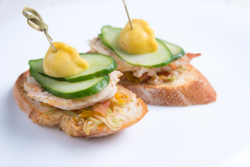 Bruschetta crostini with chopped vegetables, fried chicken, cucumber and squash. Italian cuisine