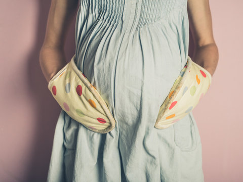 Pregnant woman with oven gloves