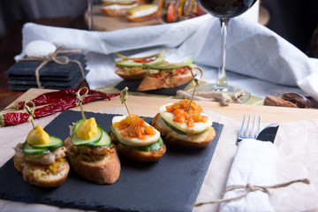 Bruschetta crostini set on a slate plate with a glass of wine. The composition of the Italian food.