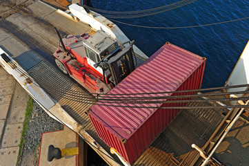 Fototapeta na wymiar loader with container entering the oceanic ferry ship