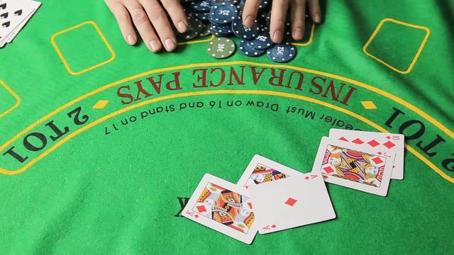 Casino table with poker player hands and playing card