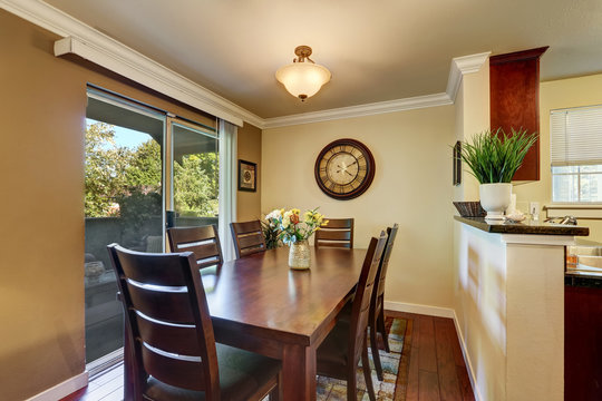 Dining area with nice wooden table set and fresh flowers.