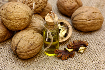Natural farmer food concept. Vintage bottle walnut oil and open nuts core on coarse cloth sacking
