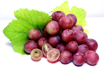 Red rose grapes bunch natural organic berry and autumn green grape leaves isolated on white background.