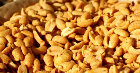 Peanuts texture. Close up of fried, peeled and salted peanuts. Photographed with natural light selective focus.