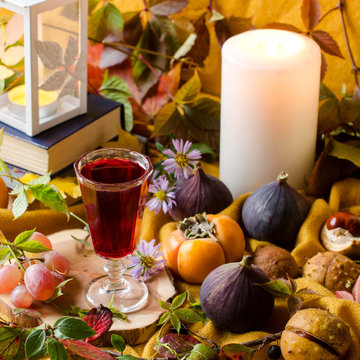 Autumn still life with candles, fruits and books.