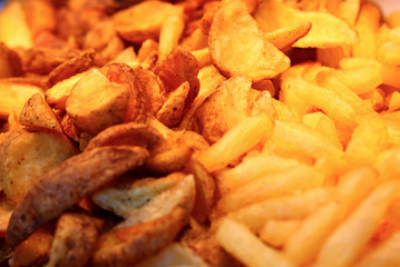 Large pan of fresh cooked sweet potato home made fries, fresh out of frying oil yellow colorful close up patterns