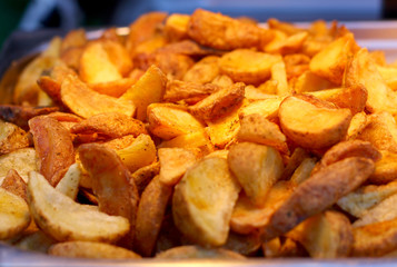 Large pan of natural food cooked sweet potato fries, fresh out of frying oil yellow colorful close up patterns