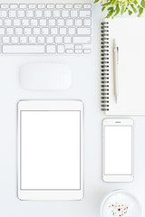 phone and tablet blank screen on white table format vertical top