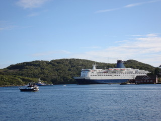 Pilot vessel guiding a cruise ship out of a fjord near Farsund, Norway.