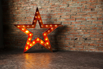 Decorative star with lamps on a background of brick wall. Modern grungy interior