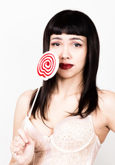 Portrait of happy beautiful young woman licking sweet candy and expressing different emotions