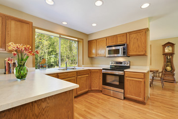 Wooden kitchen room interior with modern steel appliances.