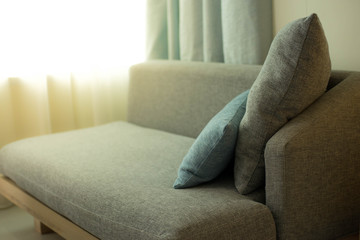 Sofa and pillows in room with warm sunshine in the morning.