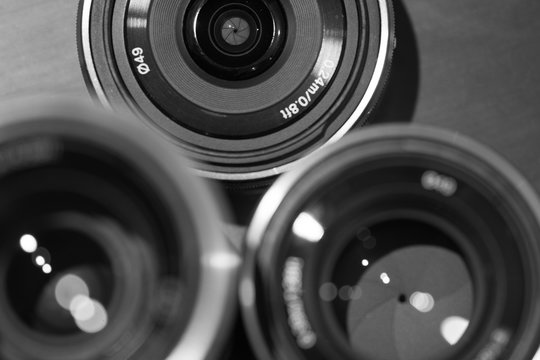 closeup macro of camera lenses with reflections low key black and white image with aperture blades