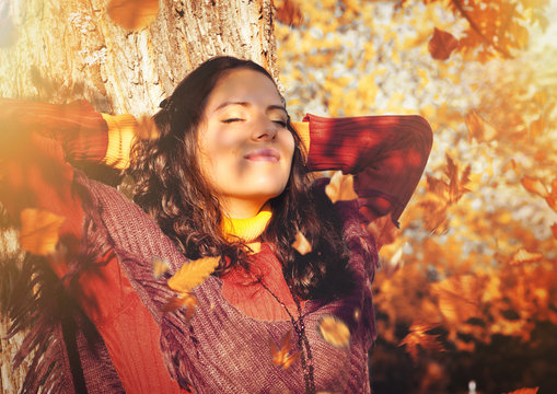 girl enjoying sunshine in park on an autumn day