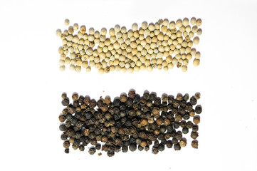 Piles stripes of black and white pepper on white background