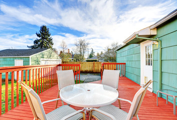 Red wooden walkout deck with table set