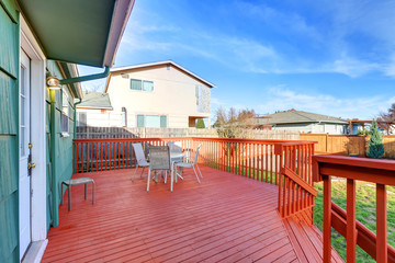 Naklejka premium Red wooden walkout deck with table set