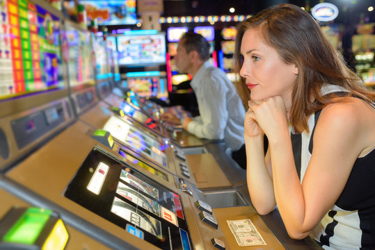 Miserable woman sat at arcade game
